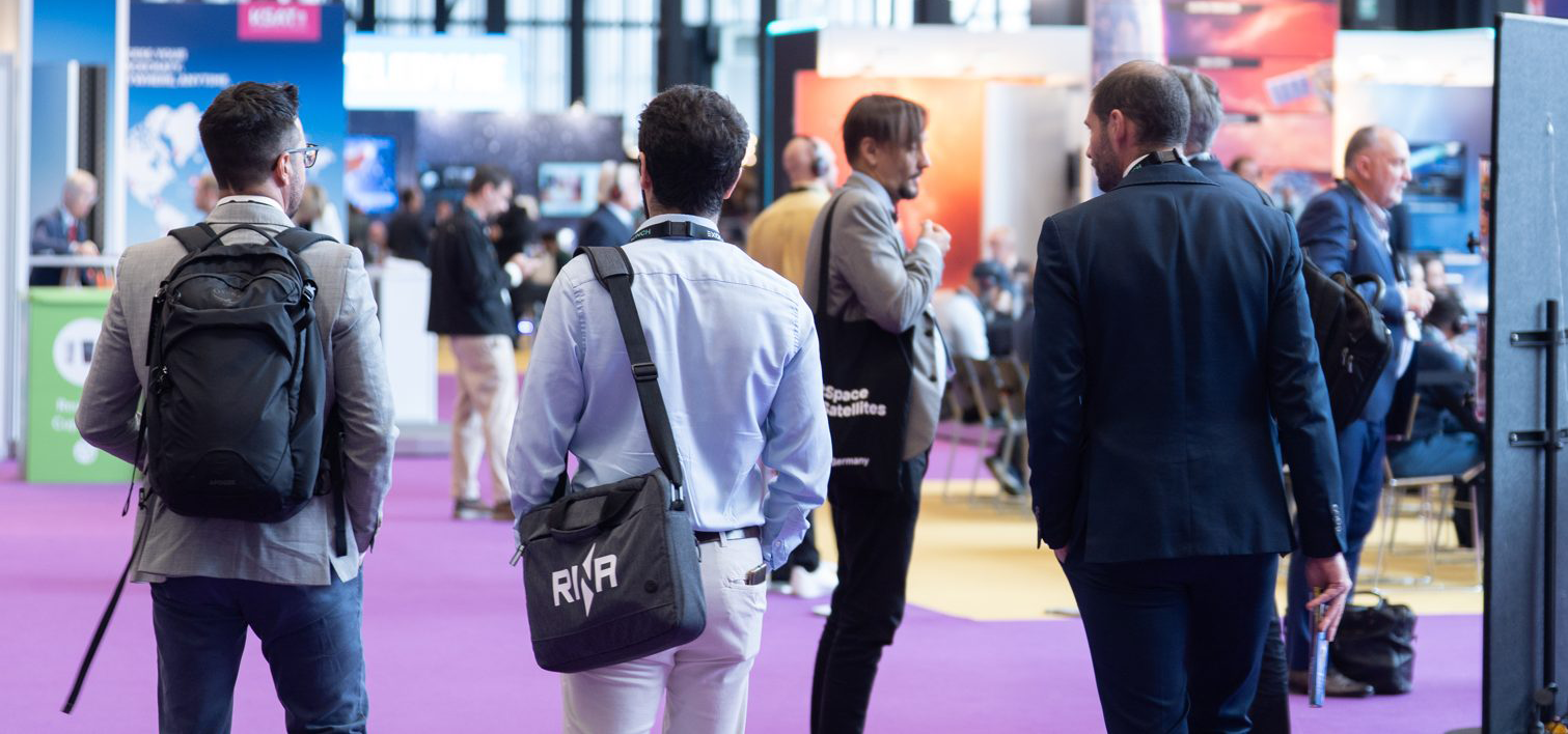 SmallSat Europe exhibition floor with attendees walking between stands
